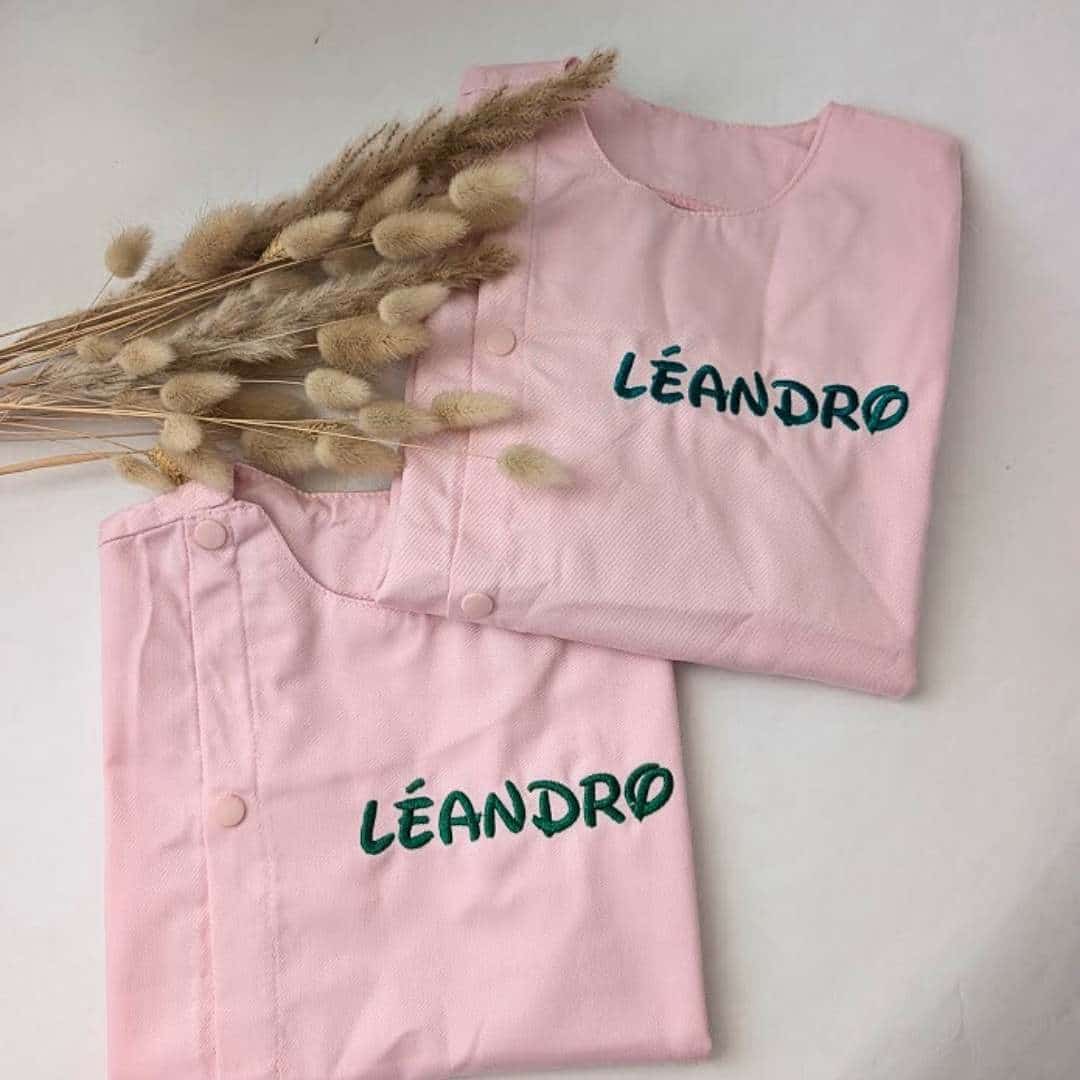 tablier ecole rose(11) Tablier en tissus pour école maternelle couleur rose modèle manches longue avec élastique au poignet pour garçon brodé du prénom en vert