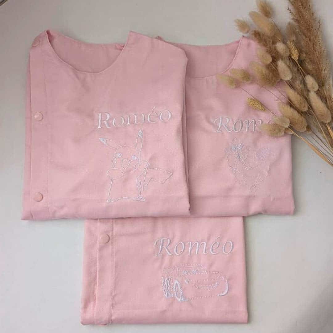 tablier ecole rose(8) Tablier en tissus pour école maternelle couleur rose modèle sans manches pour garçon brodé du prénom en blanc