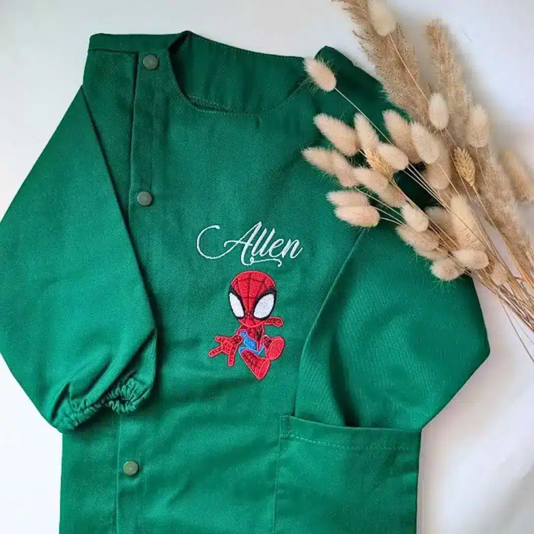 tablier maternelle vert personnalisé (3) Tablier en tissus pour école maternelle couleur vert modèle manches longues pour garçon brodé du prénom Allen en blanc