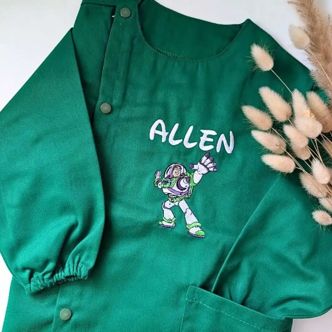 tablier maternelle vert personnalisé (4) Tablier en tissus pour école maternelle couleur vert modèle manches longues pour garçon brodé du prénom en blanc