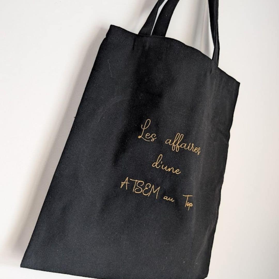 Tote bag personnalisé en coton noir brodé les affaires d'une ATSEM au top