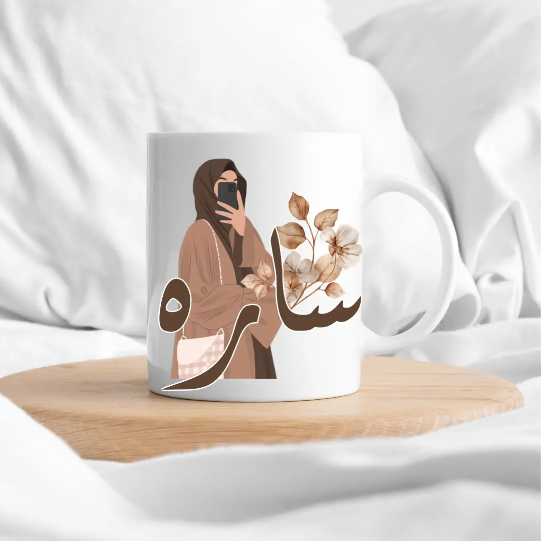 Le design représente une femme hijabi élégante, avec des couleurs douces et modernes. Le prénom personnalisé vient sublimer le design pour créer un mug unique.